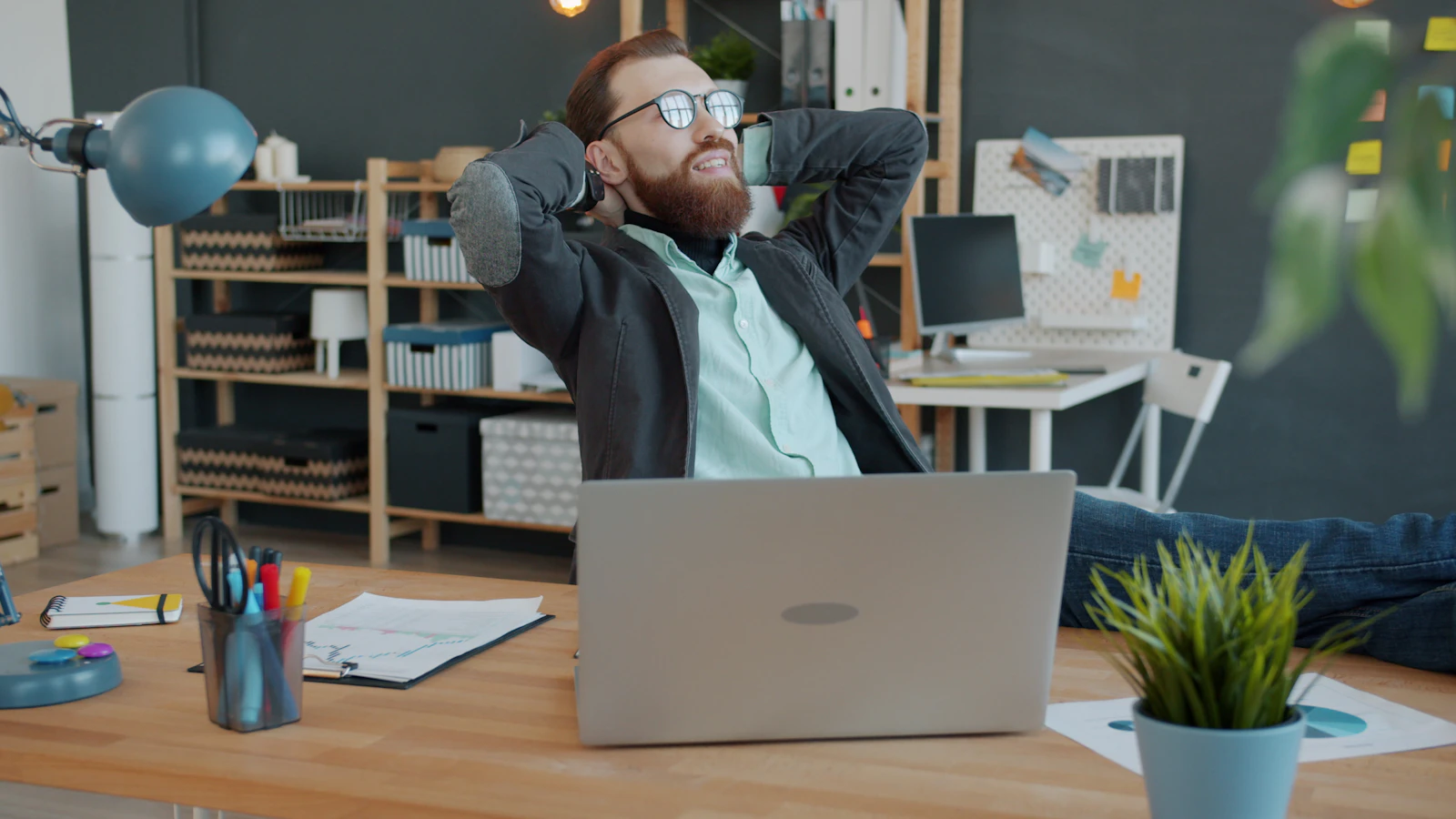 Person dehnt den Rücken während einer kurzen Pause neben ihrem Arbeitsplatz