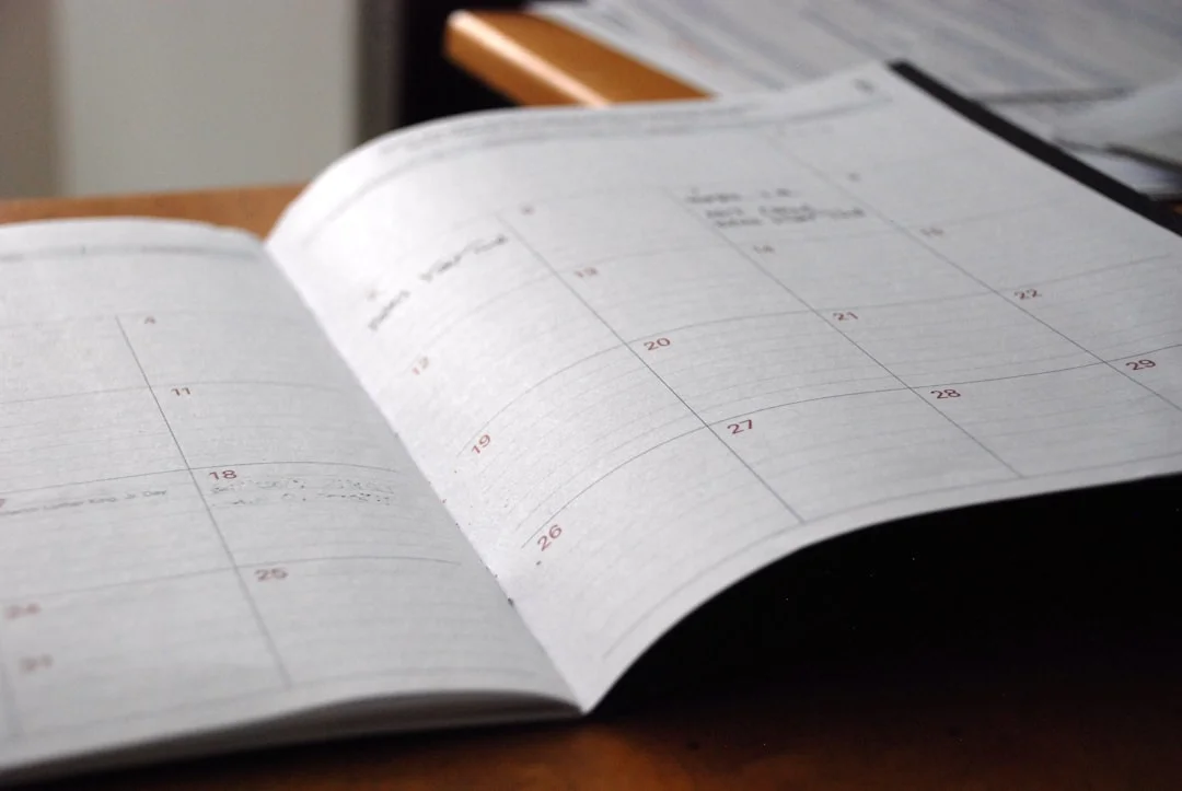 Open planner showing a week at a glance on a wooden desk
