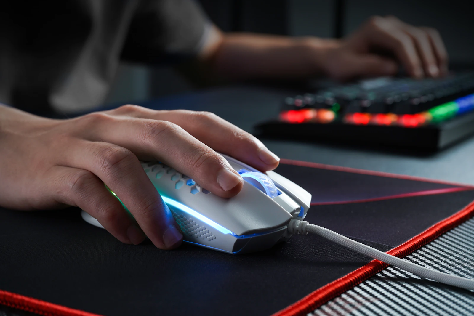 Gros plan sur les mains d'un joueur sur une souris et un clavier de gaming